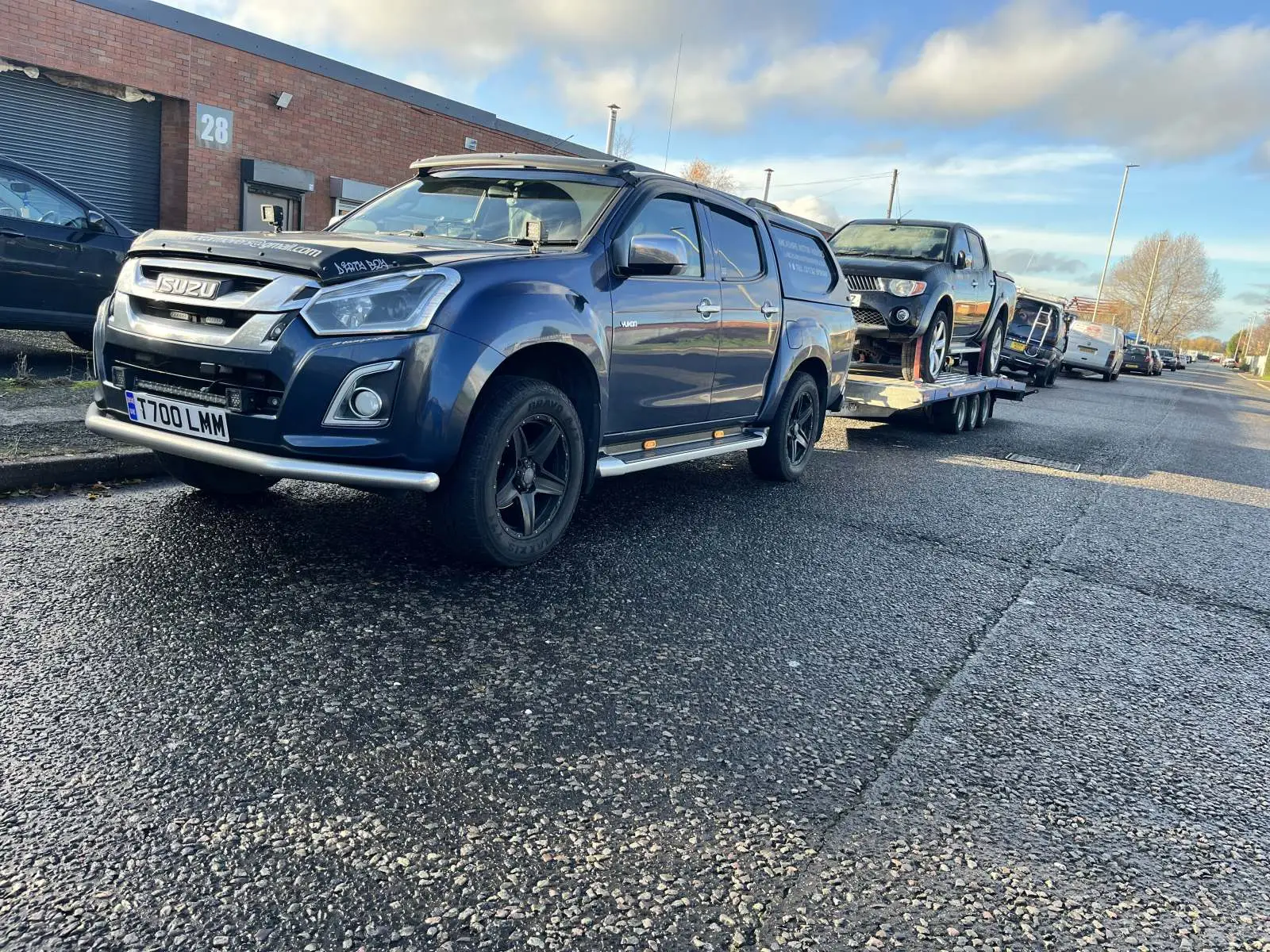 Cars lined up outside a workshop ready for transport Lancashire Motor Movers
